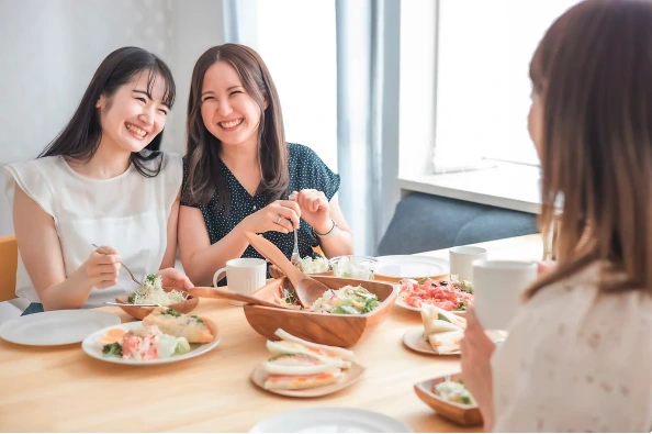 友人と笑顔で食事を楽しむ様子